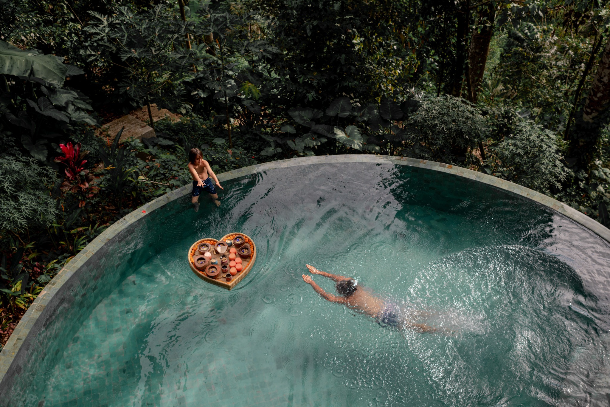 Swimmers and a floating breakfast tray in the tropical garden pool at Harmony Hill Bali