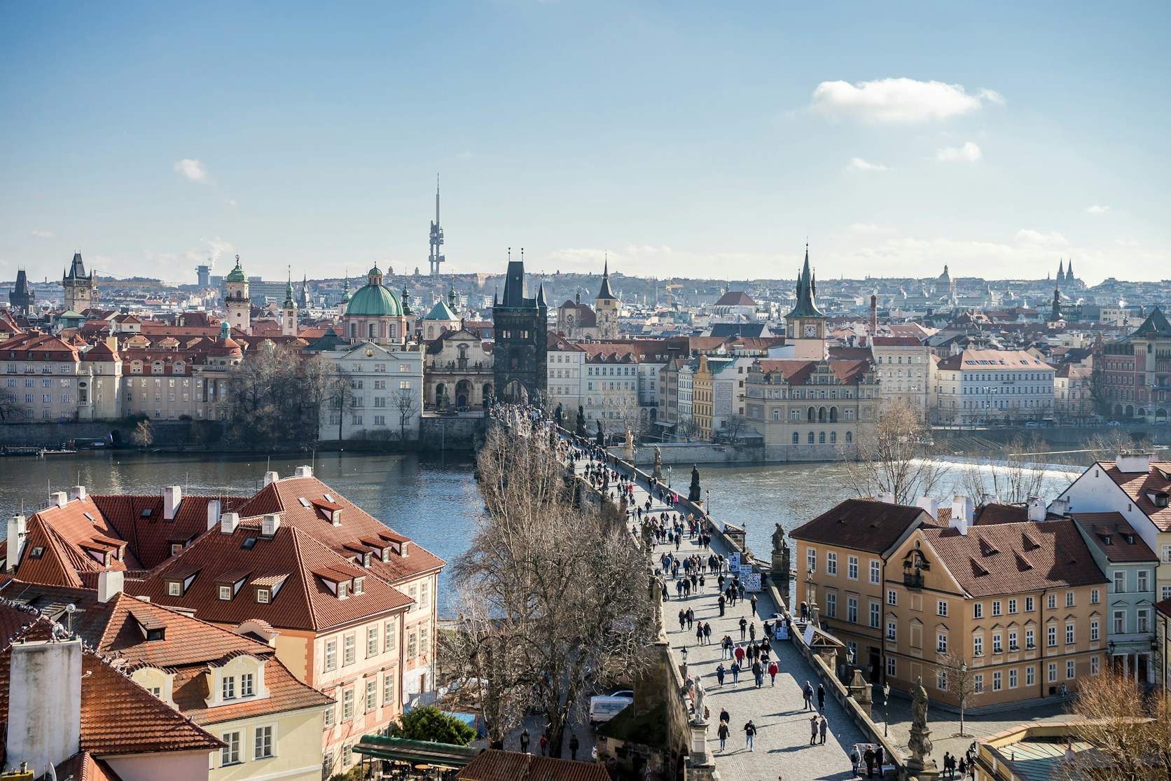 Prague rooftops and the Vltava river in a city panorama