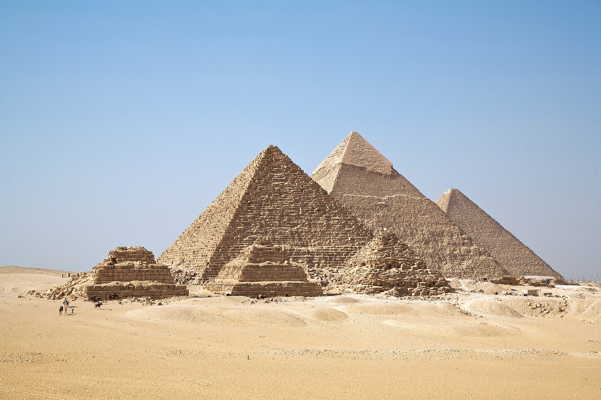 The pyramids of Giza across the desert under a clear blue sky
