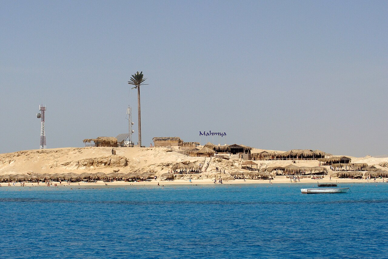 Mahmya beach, straw parasols and a small boat on the Red Sea near Hurghada