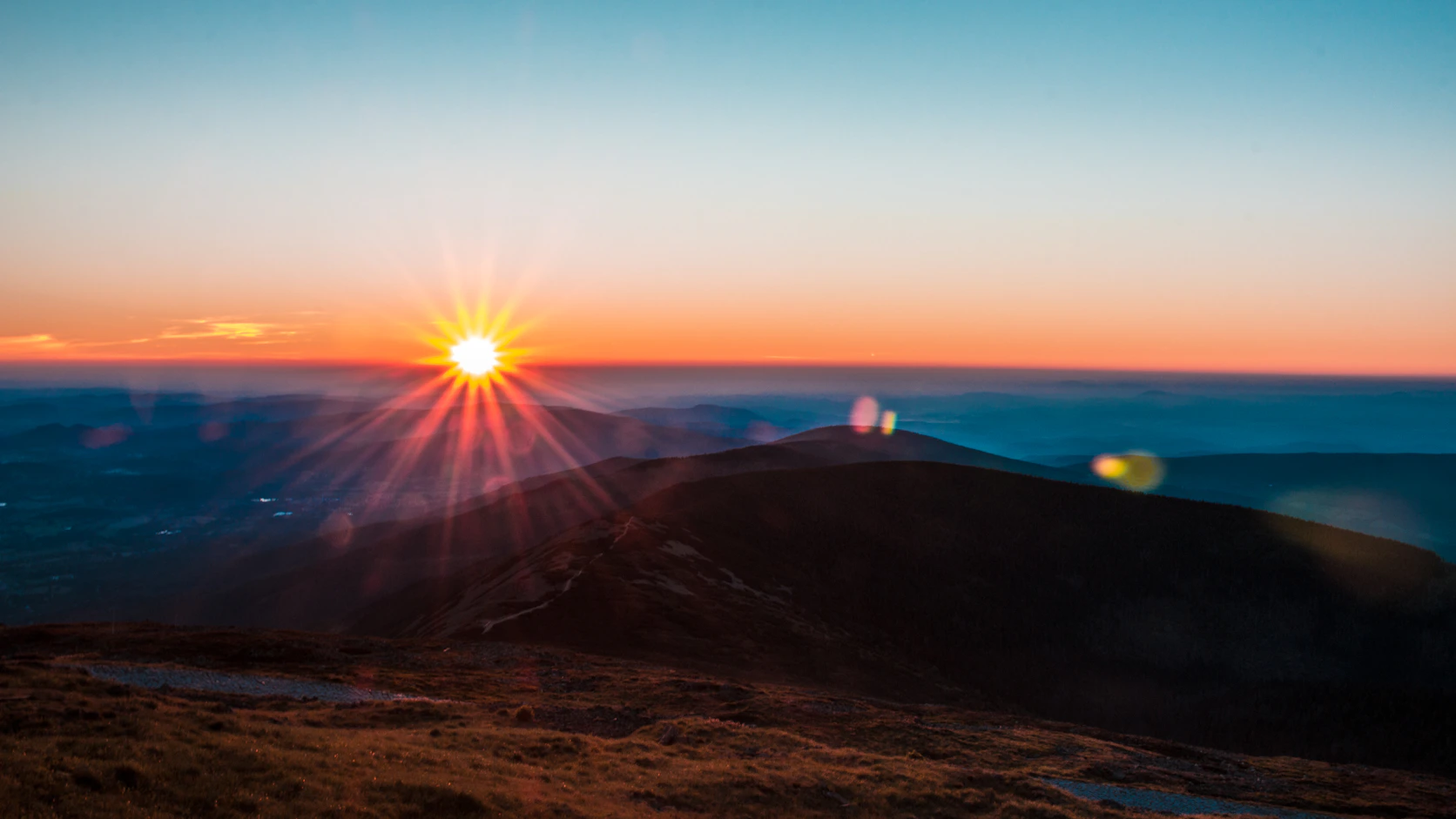 Sunrays over mountain silhouettes at Sněžka in the Krkonoše Mountains